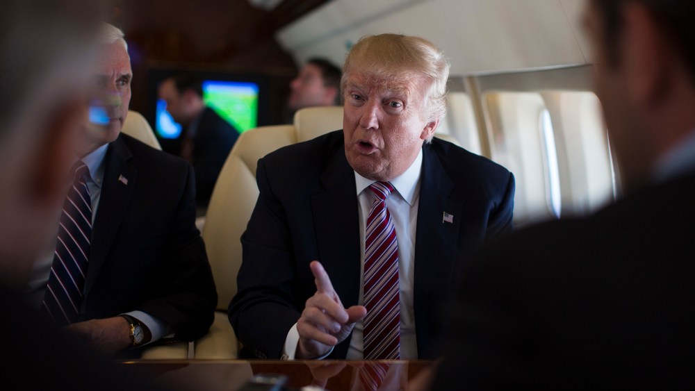 Republican presidential candidate Donald Trump talks with press on Sept. 5, 2016, aboard his campaign plane, while flying over Ohio, as Vice presidential candidate Gov. Mike Pence looks on. (Photo by Evan Vucci/AP)