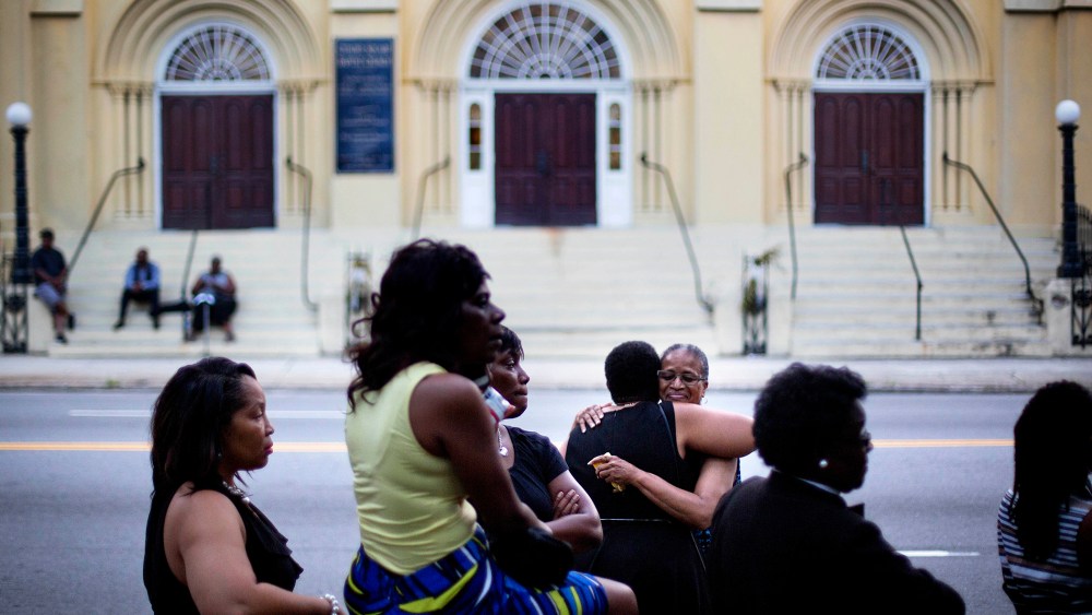 Lauretta Geddis, of Charelston, S.C., rear right, embraces Brenda T. Williams, of North Charelston, while waiting on line to enter Sen. Clementa Pinckney's funeral service, June 26, 2015, in Charleston. (Photo by David Goldman/AP)