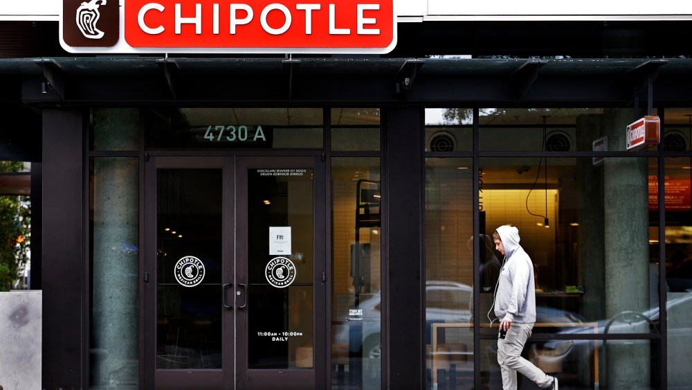 A pedestrian walks past a closed Chipotle restaurant, Nov. 2, 2015, in Seattle. (Photo by Elaine Thompson/AP)