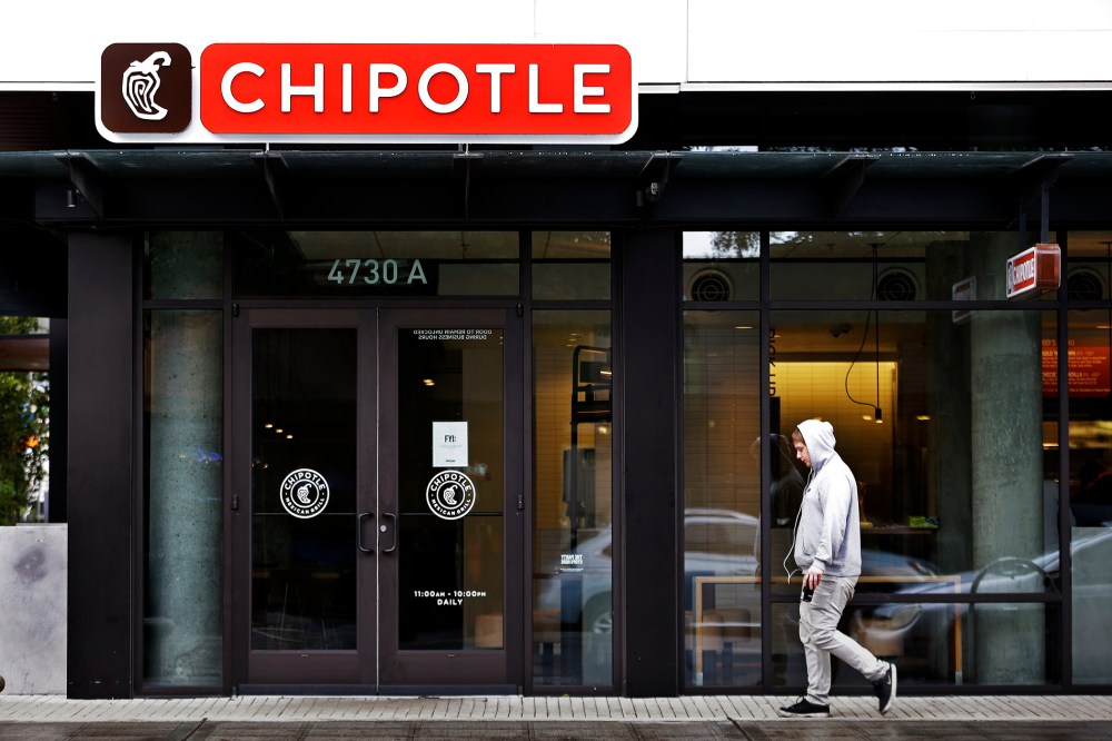 A pedestrian walks past a closed Chipotle restaurant, Nov. 2, 2015, in Seattle. (Photo by Elaine Thompson/AP)
