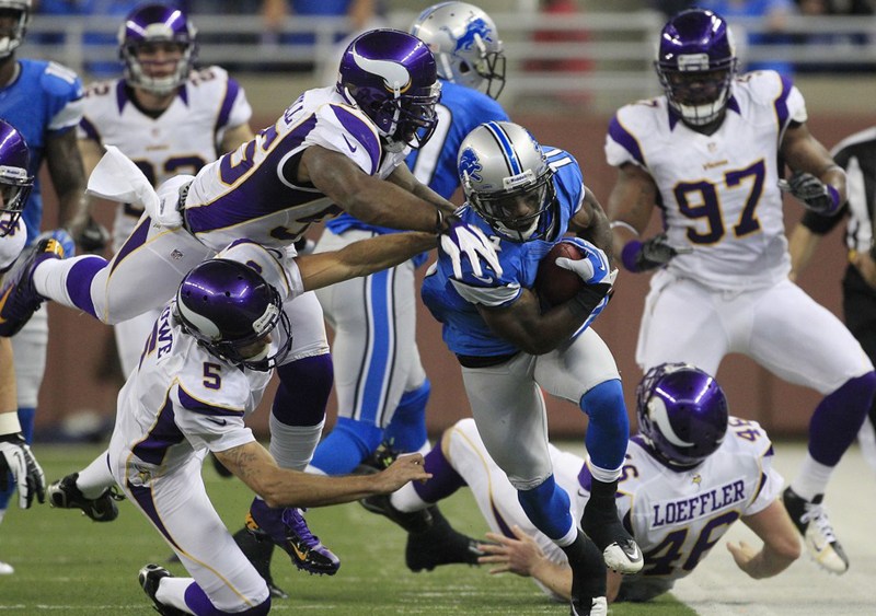 Minnesota Vikings outside linebacker Marvin Mitchell (55) and punter Chris Kluwe (5) take down Detroit Lions' Stefan Logan (11) as he returns a punt during the third quarter of an NFL football game against the Minnesota Vikings at Ford Field in Detroit...
