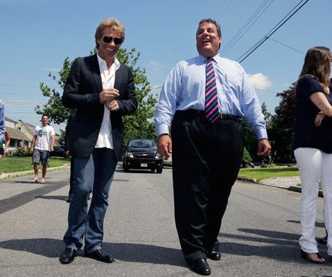 Singer Jon Bon Jovi walks in his hometown of Sayreville, N.J., with New Jersey Gov. Chris Christie on July 8, 2013. (Photo by Mel Evans, Pool/AP)