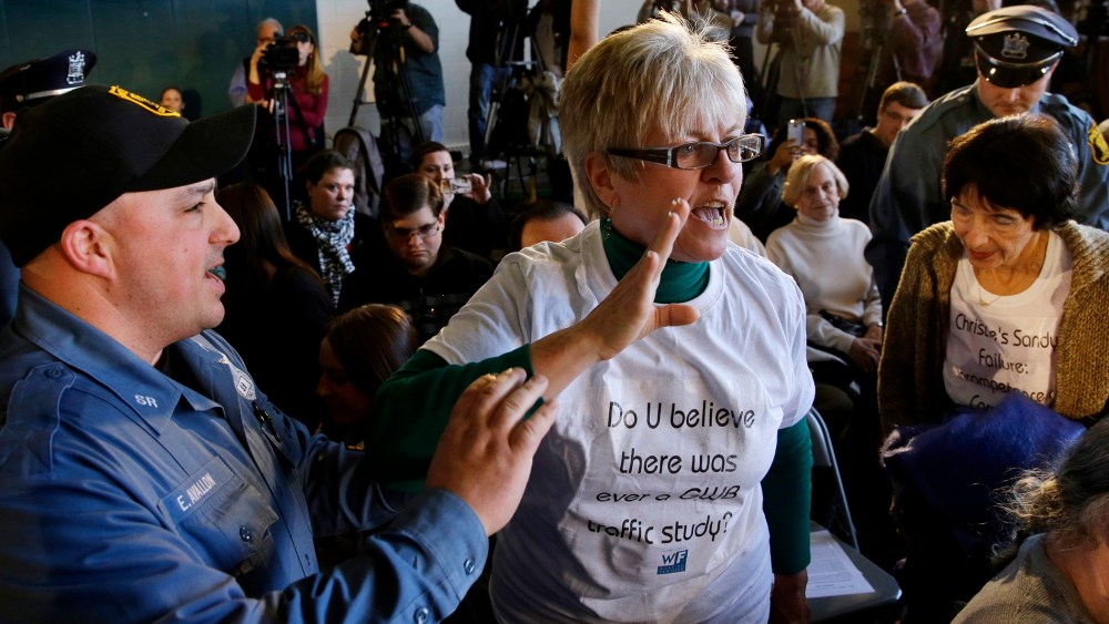 A woman shouts at New Jersey Gov. Chris Christie as South River police officers remove her from a town hall meeting on March 18, 2014 in South River, N.J.