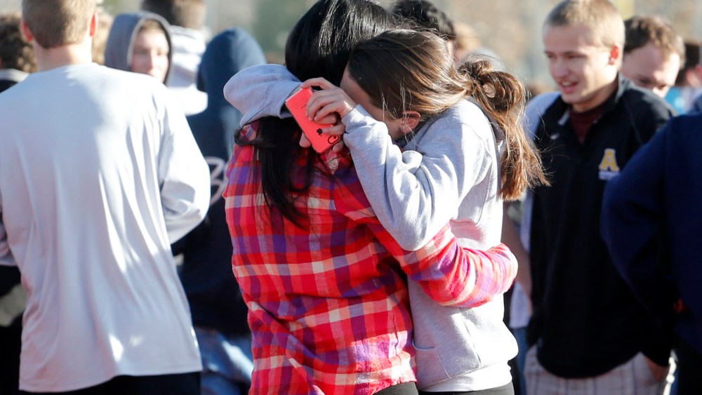 Students comfort each other outside of Arapahoe High School after a shooting on the campus in Centennial, Colo., on Friday, Dec. 13, 2013