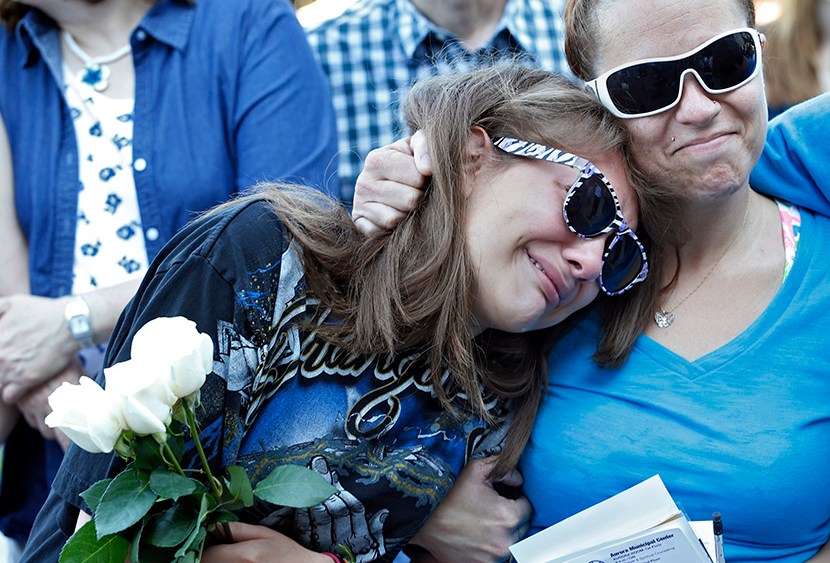 Jasmine Christman, left, is comforted by her mother Yulanda Vega Jordan during a memorial service for the victims of the Aurora theater shooting on the anniversary of the tragedy in Aurora, Colo., on Saturday, July 20, 2013. Jasmine lost a friend in...