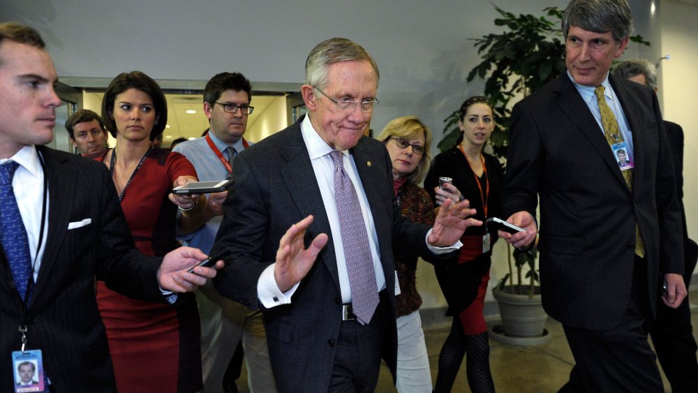 Senate Majority Leader Harry Reid of Nevada is pursued by reporters on Capitol Hill in Washington, Wednesday, Dec. 11, 2013, following a closed-door briefing on the recent agreement reached between Iran and western powers on Iran's nuclear program.