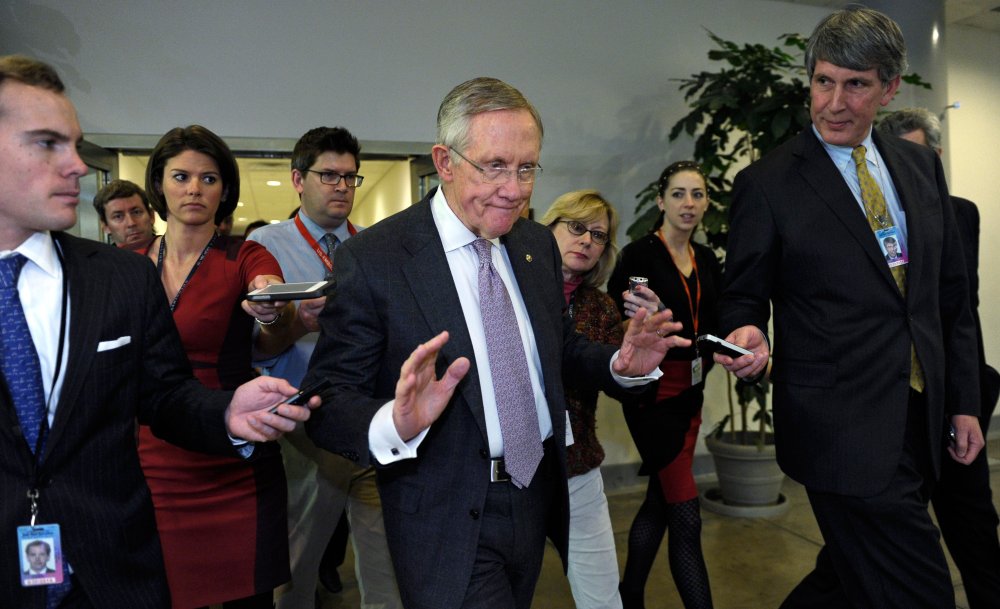Senate Majority Leader Harry Reid of Nevada is pursued by reporters on Capitol Hill in Washington, Wednesday, Dec. 11, 2013, following a closed-door briefing on the recent agreement reached between Iran and western powers on Iran's nuclear program.