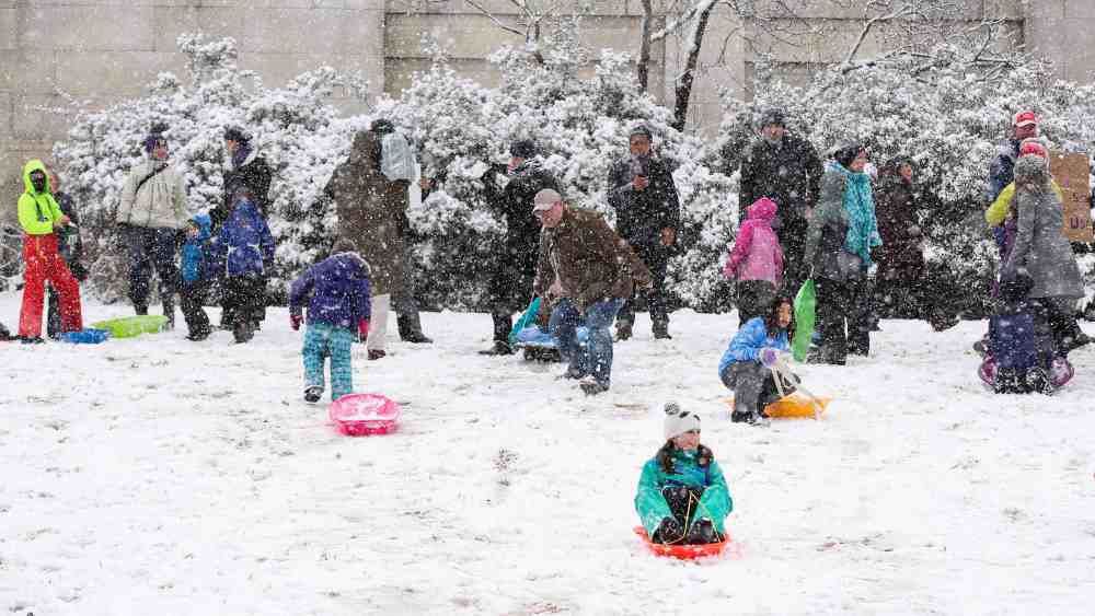 Children sled on the west lawn of the U.S. Capitol during a snow storm in Washington