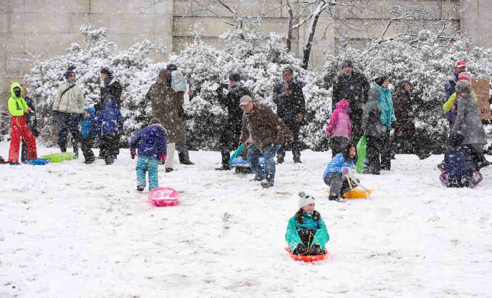 Children sled on the west lawn of the U.S. Capitol during a snow storm in Washington