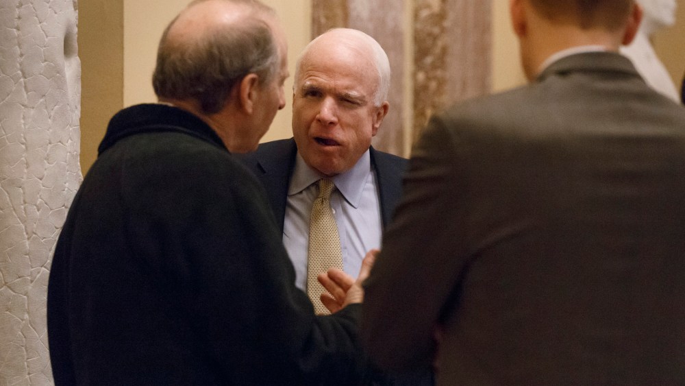 Sen. John McCain, R-Ariz., holds a meeting in the hallway outside the Senate chamber on Capitol Hill in Washington, Wednesday, Feb. 12, 2014.