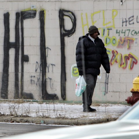 FILE - A pedestrian walks by graffiti in downtown Detroit in a Dec. 12, 2008, file photo. Detroit became the largest city in U.S. history to file for bankruptcy on Thursday, July 18, 2013, when state-appointed emergency manager Kevyn Orr asked a...