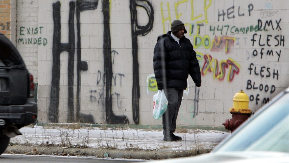 FILE - A pedestrian walks by graffiti in downtown Detroit in a Dec. 12, 2008, file photo. Detroit became the largest city in U.S. history to file for bankruptcy on Thursday, July 18, 2013, when state-appointed emergency manager Kevyn Orr asked a...