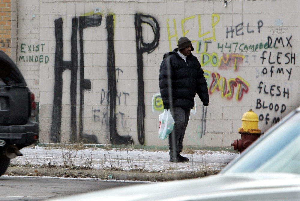 FILE - A pedestrian walks by graffiti in downtown Detroit in a Dec. 12, 2008, file photo. Detroit became the largest city in U.S. history to file for bankruptcy on Thursday, July 18, 2013, when state-appointed emergency manager Kevyn Orr asked a...