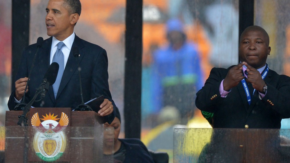 President Barack Obama delivers a speech next to a sign language interpreter during the memorial service for late South African President Nelson Mandela at Soccer City Stadium in Johannesburg, Dec. 10, 2013.