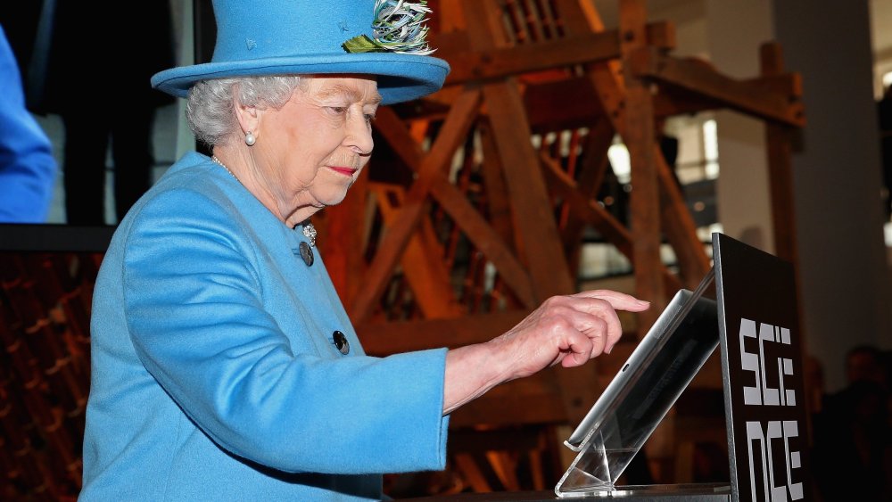 Britain's Queen Elizabeth II sends her first tweet during a visit to open the 'Information Age' exhibition at the Science Museum in London on Oct. 24, 2014.
