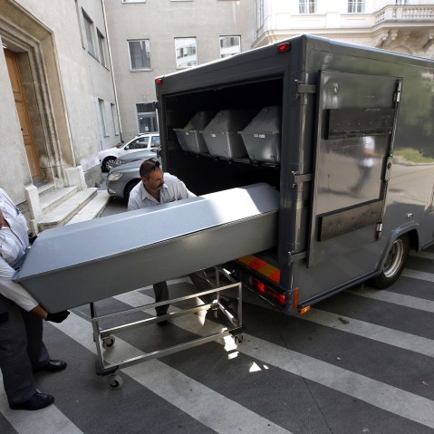 Coffins with bodies of migrants who died in an abandoned lorry are unloaded from a van on Aug. 28, 2015 for an investigation at a forensics institute in Vienna. (Photo by Dieter Nagl/AFP/Getty)