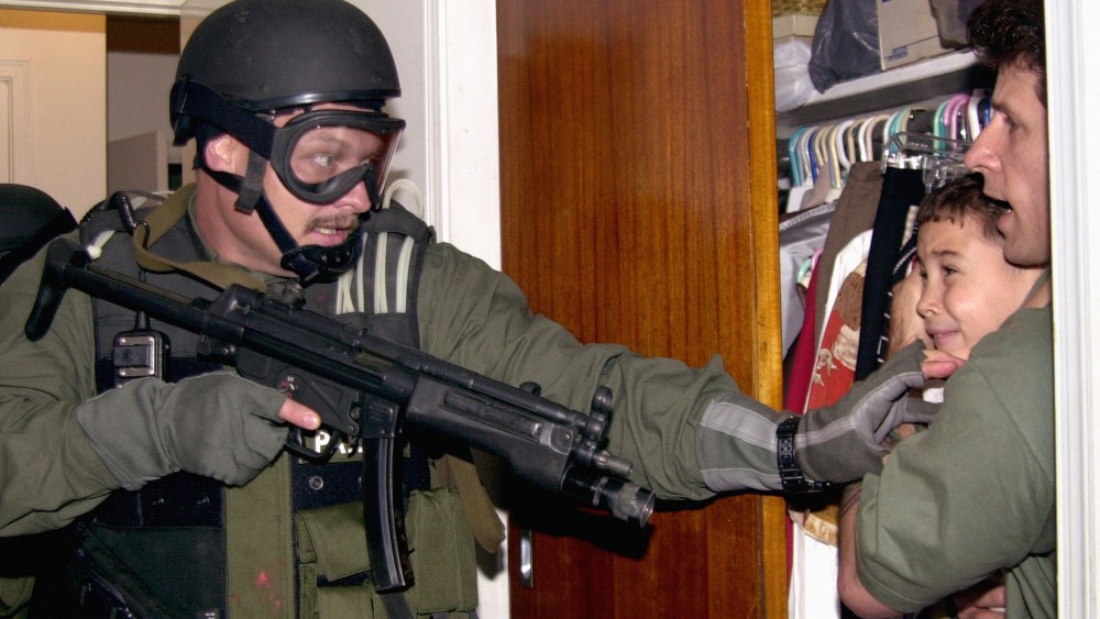 In this fourth of seven sequential photos, Elian Gonzalez is held in a closet by Donato Dalrymple, right, as government officials search the home of Lazaro Gonzalez for the young boy, early Saturday morning, April 22, 2000, in Miami. (AP Photo/Alan Diaz)