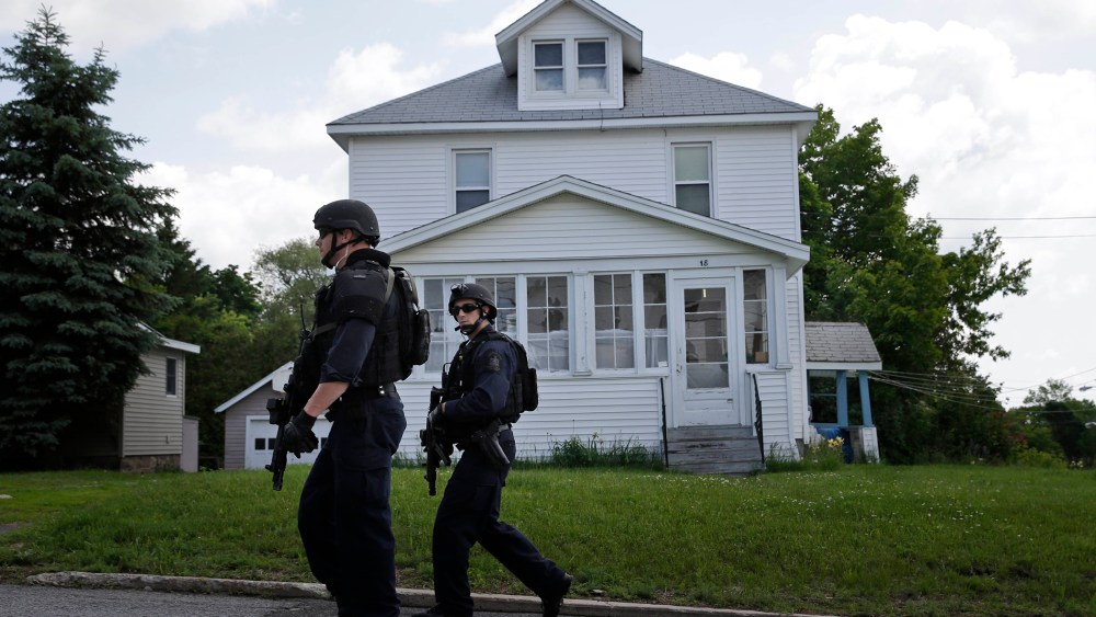 Law enforcement officers walk the streets near the prison in Dannemora, N.Y., as they searched houses near the maximum-security prison in northern New York where two killers escaped using power tools, June 10, 2015.