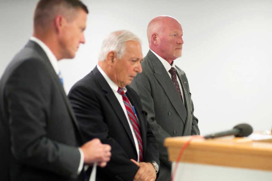 Suspended Clinton Correctional Facility corrections officer Gene Palmer, right, and attorney William J. Dreyer, center, appear in Plattsburgh Town Court as Palmer faces charges. (Photo by Ken Maldonado/New York Daily News/AP)