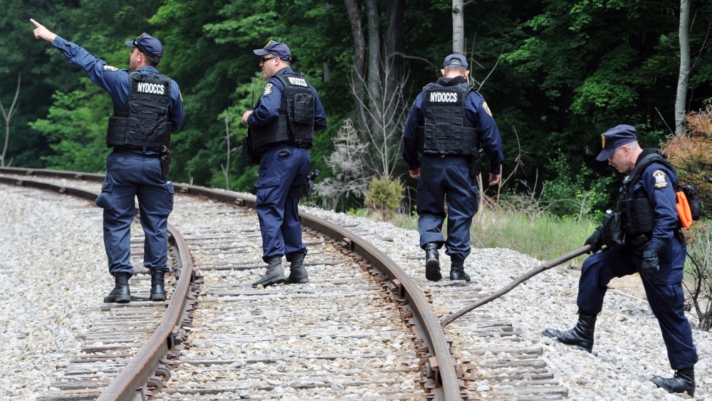 New York State Department of Corrections officers search the railroad tracks after a possible sighting of the two murder convicts who escaped from a northern New York prison two weeks ago June 21, 2015, in Friendship, N.Y. (Photo by Gary Wiepert/AP)
