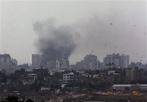 Birds fly as a plume of smoke is seen over central Gaza Strip, after an airstrike by Israeli forces, as seen from the Israel Gaza border, Monday, Nov. 19, 2012. Israeli aircraft struck crowded areas in the Gaza Strip and killed a senior militant with a...