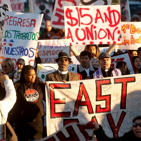 Demonstrators demanding an increase in worker wages march to a Jack in The Box fast food outlet in Oakland