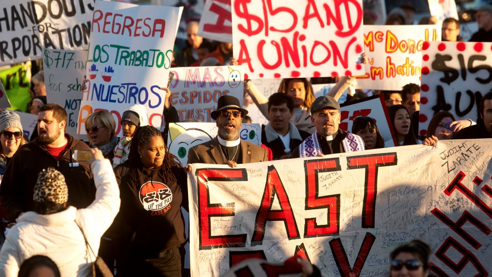 Demonstrators demanding an increase in worker wages march to a Jack in The Box fast food outlet in Oakland