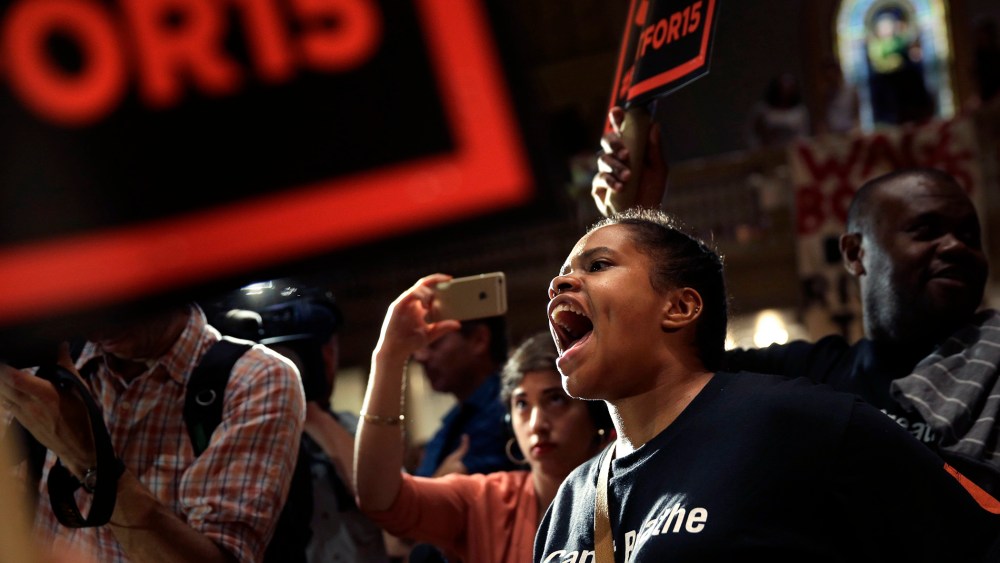 Supporters rally before a meeting of the wage board in New York, June 15, 2015. (Photo by Seth Wenig/AP)