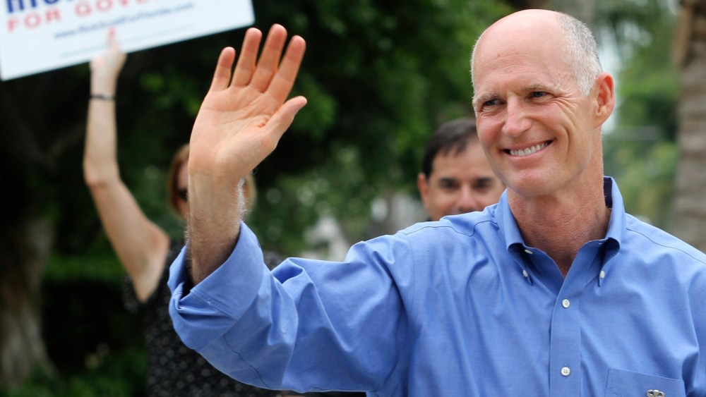 File Photo: Florida Republican Gubernatorial candidate Rick Scott greets supporters near his precinct Tuesday Aug. 24, 2010, in Naples, Fla. (Photo by Erik Kellar/AP Photo/File)