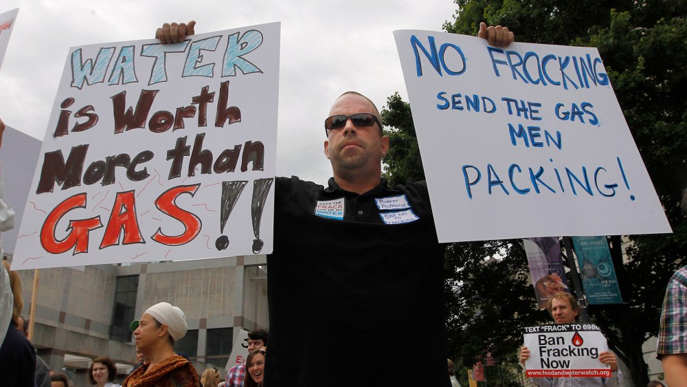 Robert Alpaugh holds signs during a march down the Bicentennial Mall to the Legislative Building in Raleigh, N.C., Tuesday, June 5, 2012.