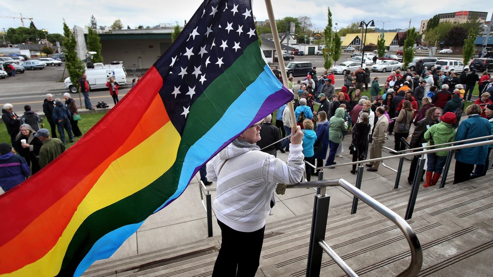 Teresa Shelley waves a rainbow-colored American flag on the steps of The Wayne L. Morse United States Courthouse on April 22, 2014 in Eugene, Ore.