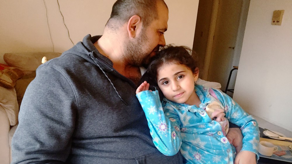 Amjad and his daughter rest in their home in Ohio. (Photo by Amanda Sakuma)