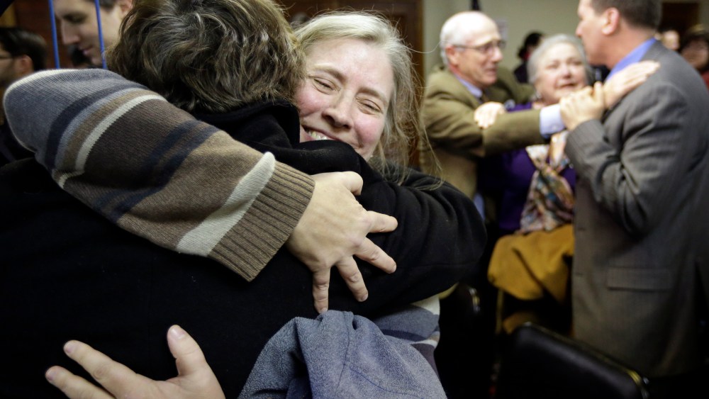 C. Kelly Smith, of Providence, R.I., center, a member of Marriage Equality Rhode Island, hugs fellow member Wendy Becker, left, also of Providence, after a house committee vote on gay marriage at the Statehouse, in Providence, Tuesday, Jan. 22, 2013....