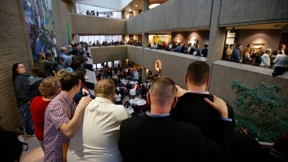 Same-sex couples, accompanied by their friends and family members, line up to get marriage licenses at the Salt Lake County clerk's office Monday, December 23, 2013.
