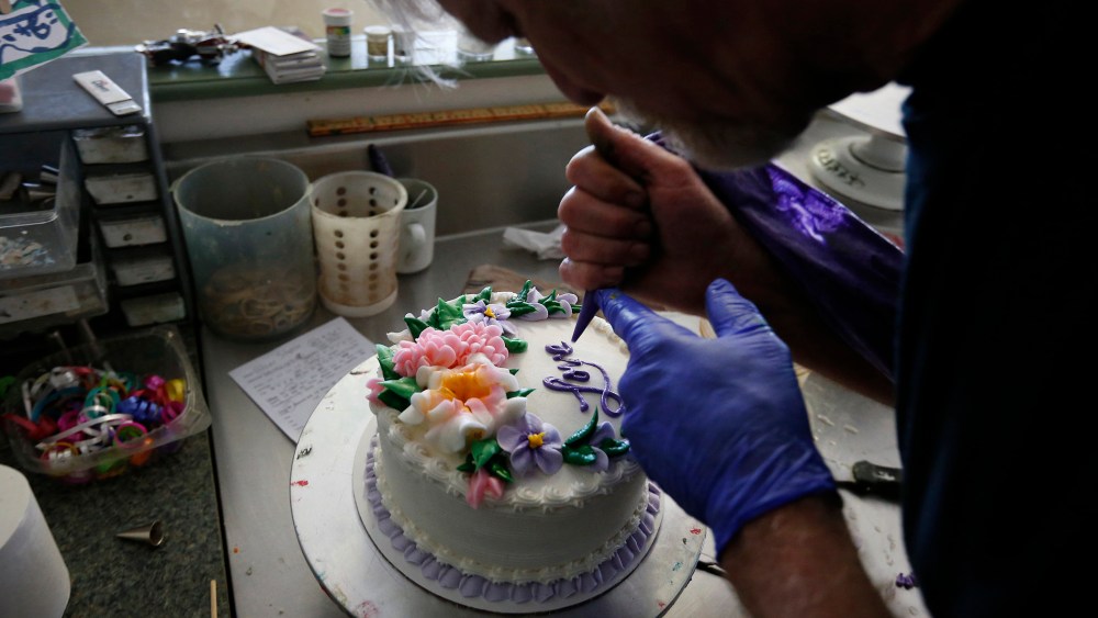 Masterpiece Cakeshop owner Jack Phillips decorates a cake inside his store, in Lakewood, Colo.