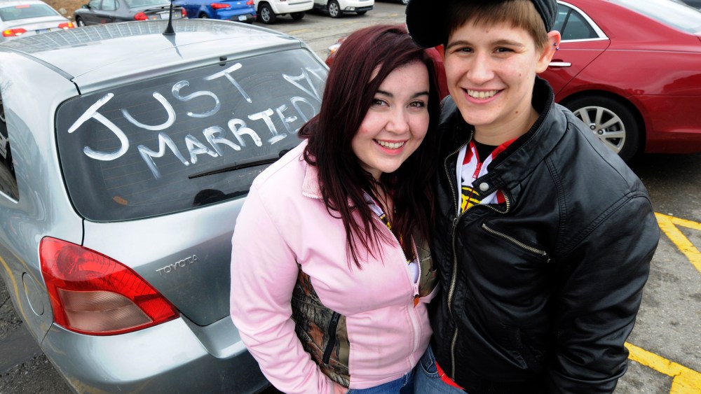 Megan D'Annunio, left, and Shannon D'Annunzio pose next to their car following their wedding ceremony, Saturday March 22, 2014, at the Oakland County Court complex in Pontiac, Michigan.