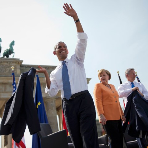 President Obama waves next to German Chancellor Angela Merkel (C) and Berlin Mayor Klaus Wowereit (R) after giving a speech in Berlin on June 19, 2013. He will answer questions about student debt through texts this week. (Photo by Michael Kappeler...