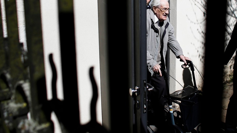 Former SS guard Oskar Groening, center, leaves the court building after the first day of the trial against him in Lueneburg, northern Germany, on April 21, 2015.