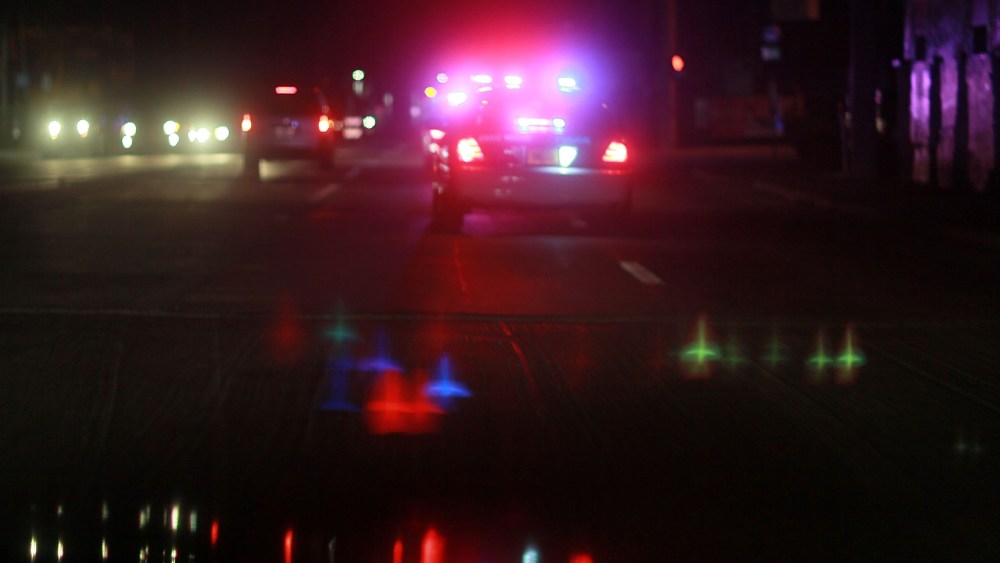 A police car with lights ablaze responds to a call. (Photo by Joe Raedle/Getty)