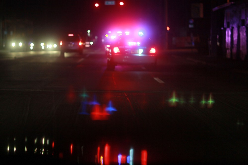 A police car with lights ablaze responds to a call. (Photo by Joe Raedle/Getty)