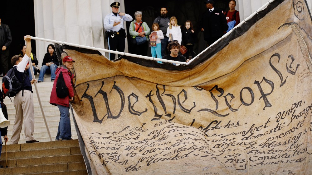 Volunteers unfurl a giant banner printed with the Preamble to the United States Constitution during a demonstration at the Lincoln Memorial on the National Mall Oct. 20, 2010 in Washington, DC. (Photo by Chip Somodevilla/Getty)