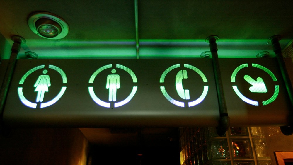 A sign points the way to the bathrooms, July 16, 2002. (Photo by Joe Raedle/Getty)