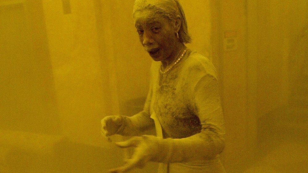 This Sept. 11, 2001 file photo shows Marcy Borders covered in dust as she takes refuge in an office building after one of the World Trade Center towers collapsed in New York. (Photo by Stan Honda/AFP/Getty)