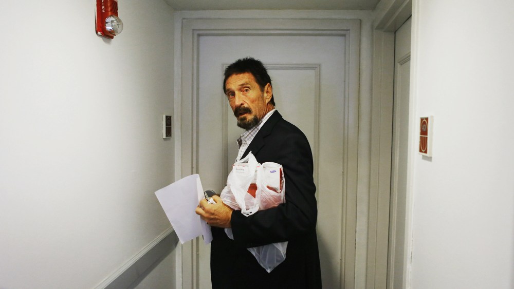 John McAfee enters a room at the Beacon Hotel where briefly stayed after arriving from Guatemala on December 13, 2012 in Miami Beach, Florida. (Photo by Joe Raedle/Getty)