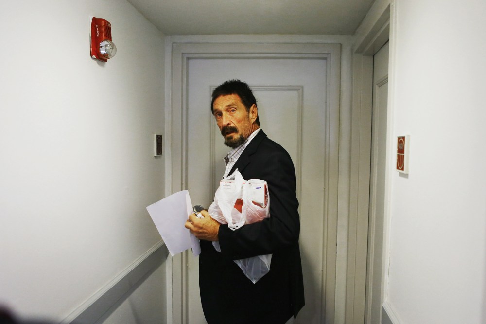 John McAfee enters a room at the Beacon Hotel where briefly stayed after arriving from Guatemala on December 13, 2012 in Miami Beach, Florida. (Photo by Joe Raedle/Getty)