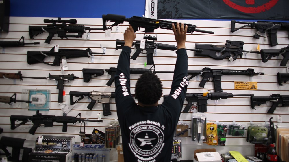 A man puts a weapon on display (Photo by Joe Raedle/Getty).