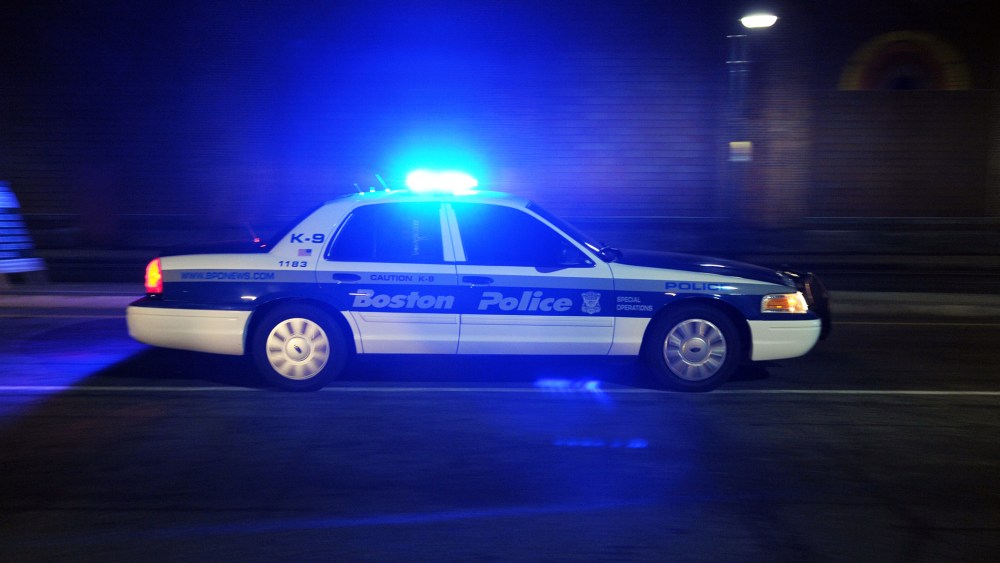 A Boston Police Department car drives down a street. (Photo by Stan Honda/AFP/Getty)