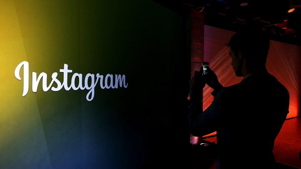 An attendee takes a photo of the Instagram logo during a press event. (Photo by Justin Sullivan/Getty)