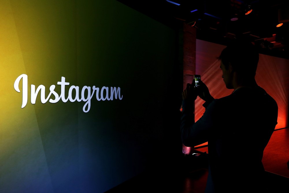 An attendee takes a photo of the Instagram logo during a press event. (Photo by Justin Sullivan/Getty)