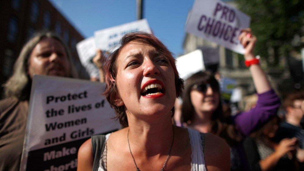 A Pro-Choice supporter holds placards in front of the gates of the Irish Parliament building in Dublin on July 10, 2013 ahead of a vote to introduce abortion in limited cases where the mother's life is at risk. (Photo by Peter Muhly/AFP/Getty)